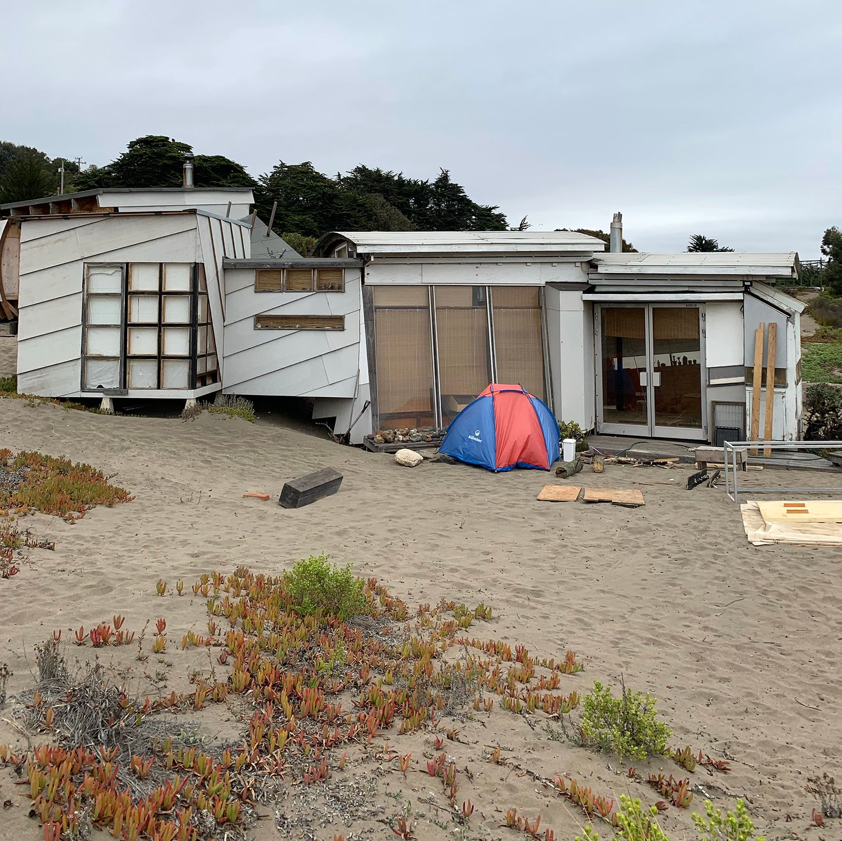 House under construction with camping tent