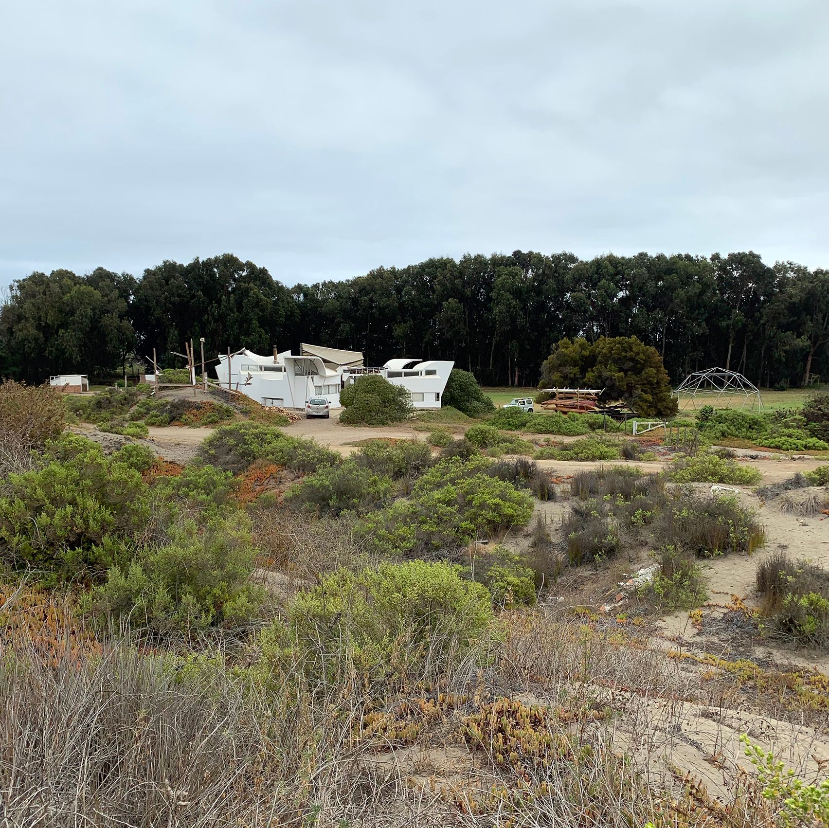 House in a green field with geodesic dome frame